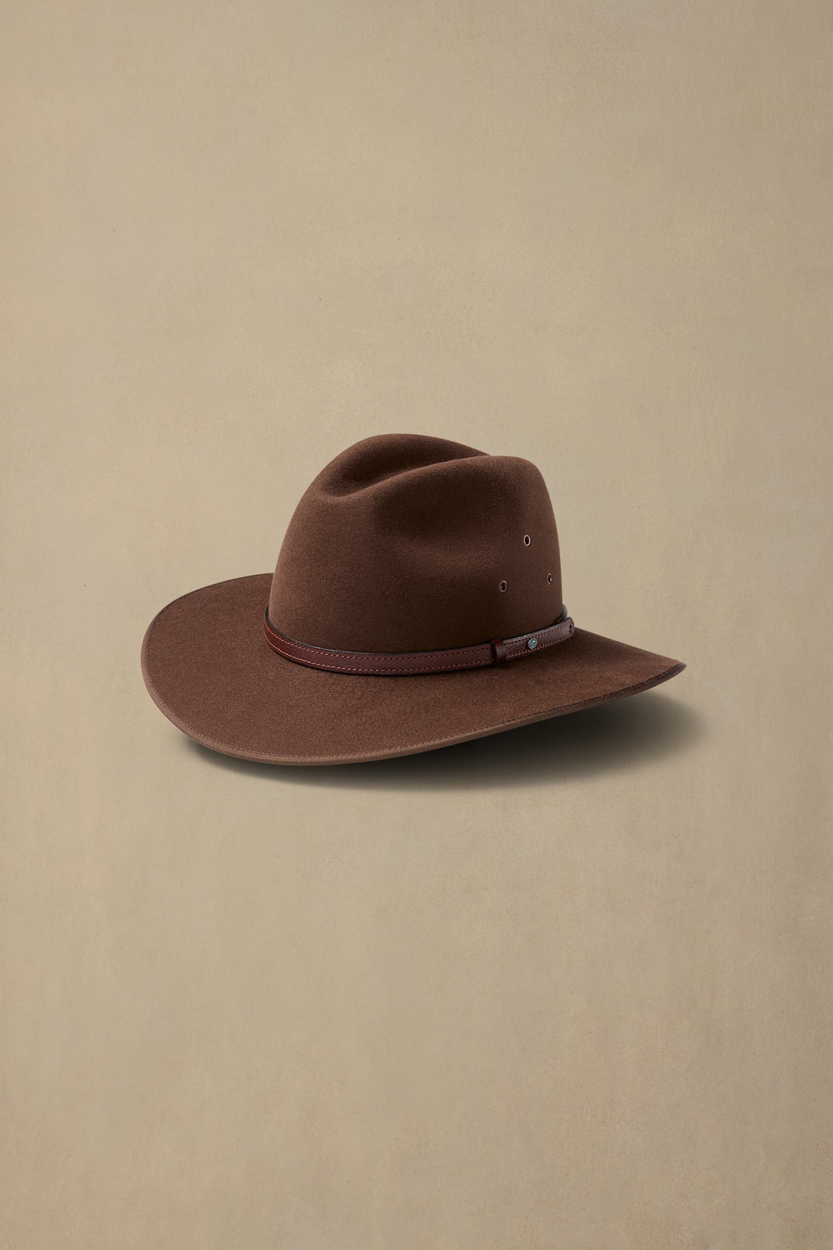 Brown fur felt Coober Pedy cowboy hat with leather band on neutral background
