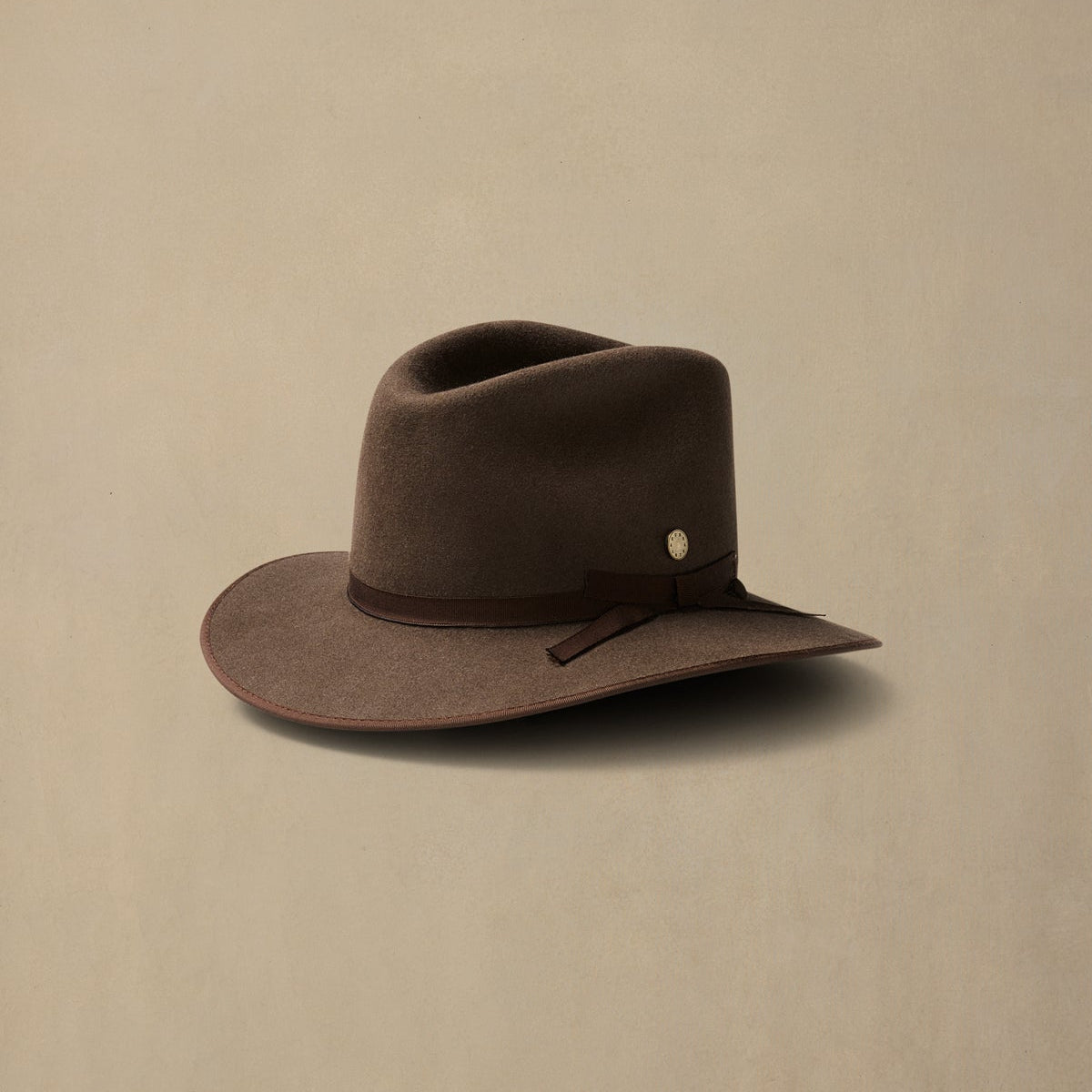 Mid brown rabbit fur felt cowboy hat with dark ribbon band, displayed against neutral background