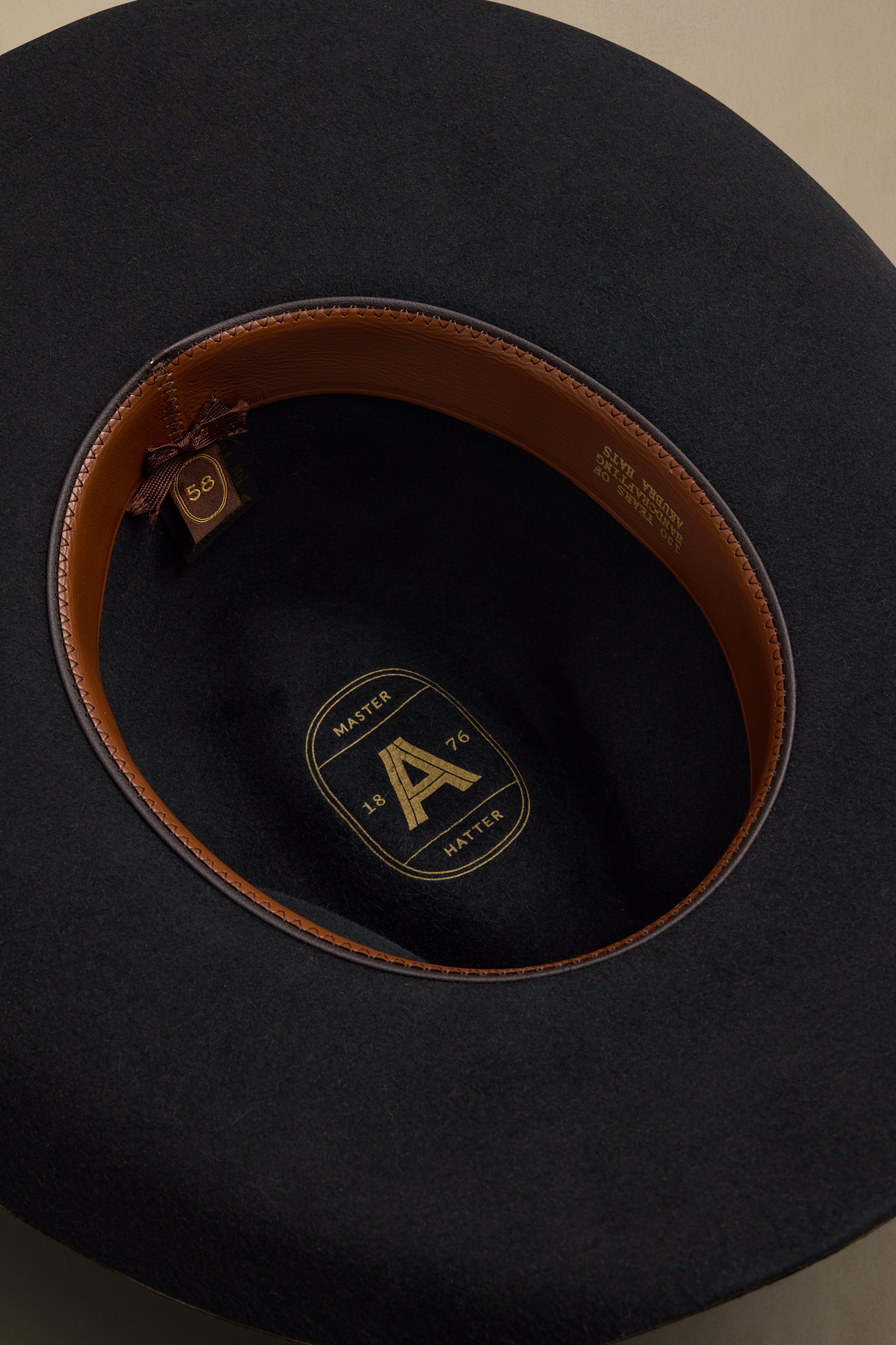 Black fur felt Dusty Dawn cowboy hat displayed from above showing brown leather interior and size 58 tag