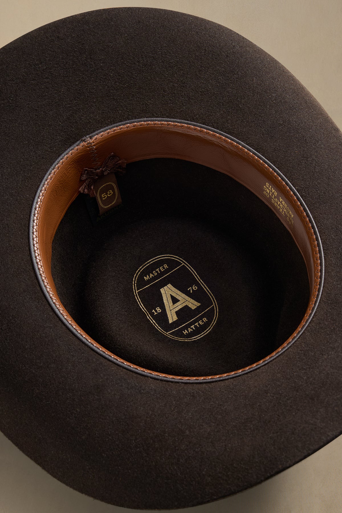 Charcoal rabbit fur hat interior view showing tan leather band and Master Hatter size badge