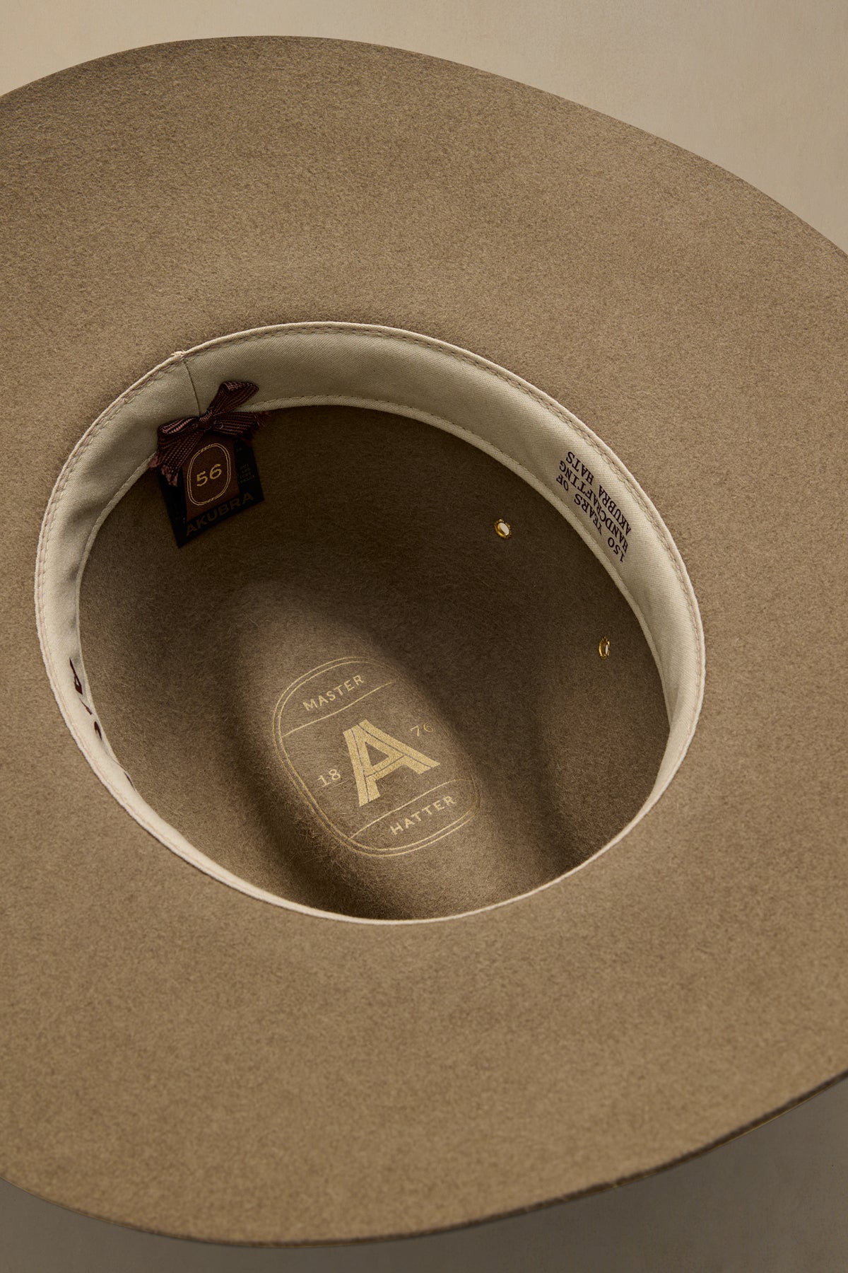 Tan fur felt traveller hat viewed from above showing interior label and sizing details with cream sweatband