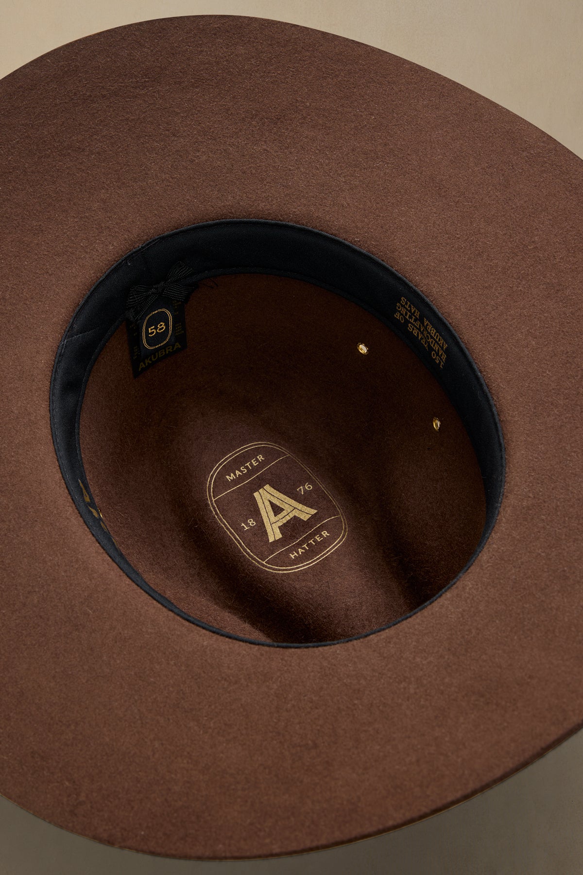 Brown rabbit fur traveller hat interior view showing size 58 label and brand badge with black ribbon band