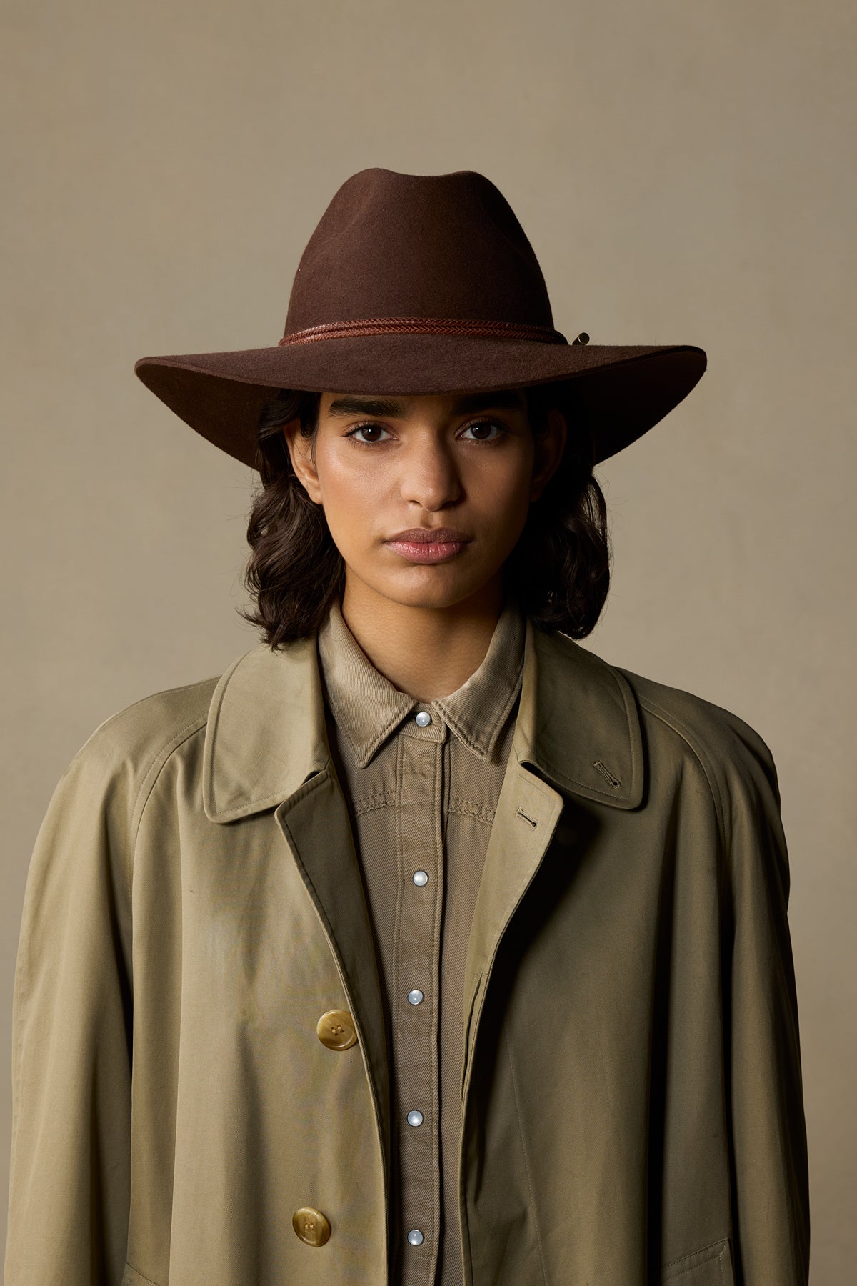 Brown felt Traveller hat with rope band worn with tan jacket on neutral background