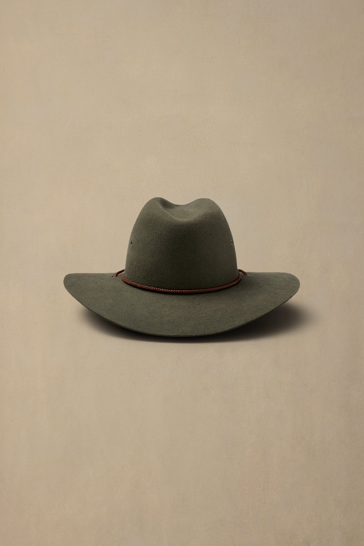 Sage green rabbit fur felt cowboy hat with red cord band on cream background