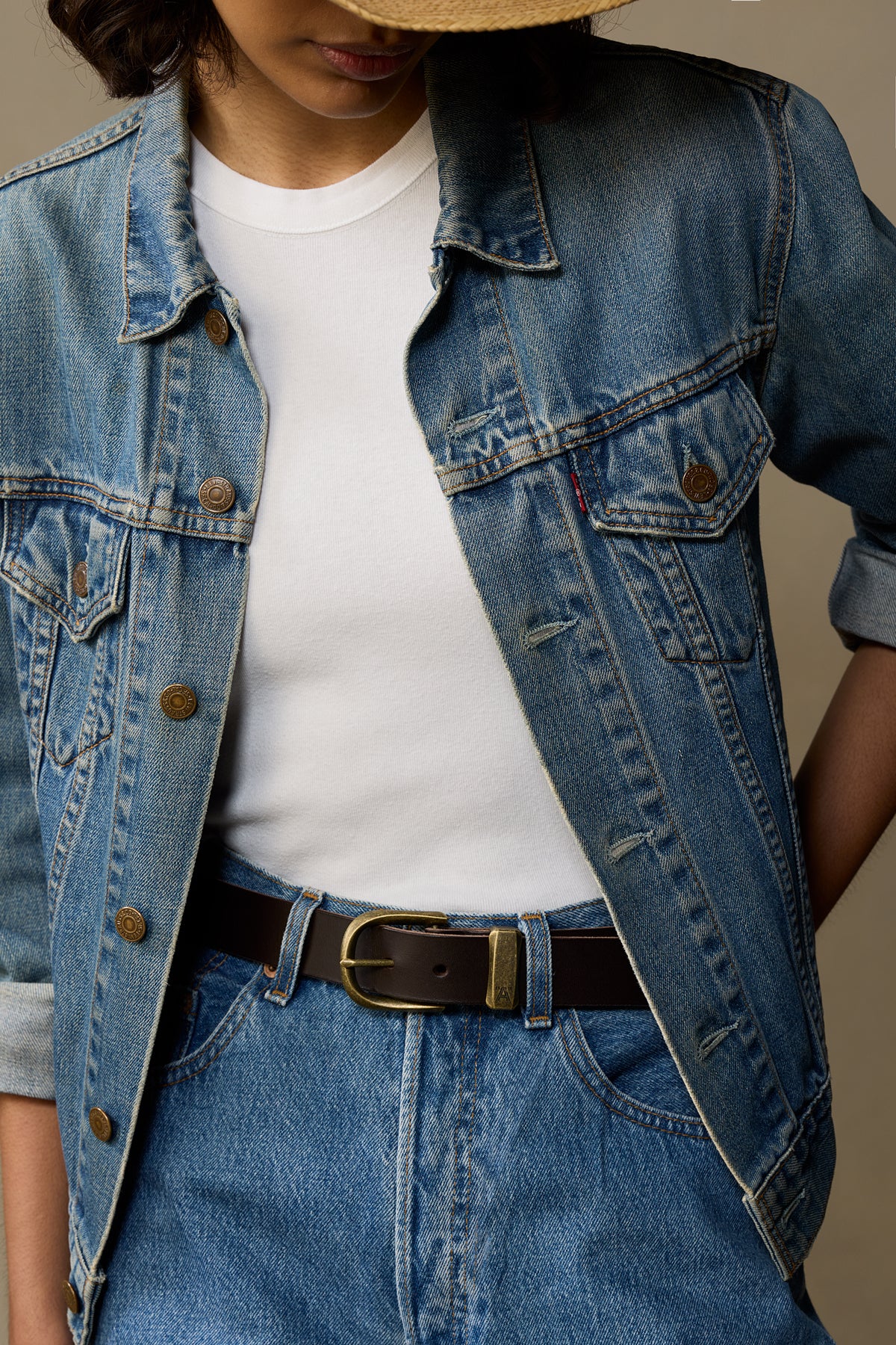 Black leather belt with brass buckle worn with denim jacket and jeans