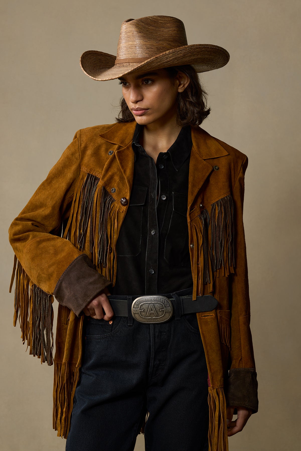 Black leather belt with silver pewter buckle worn with brown fringe jacket and cowboy hat