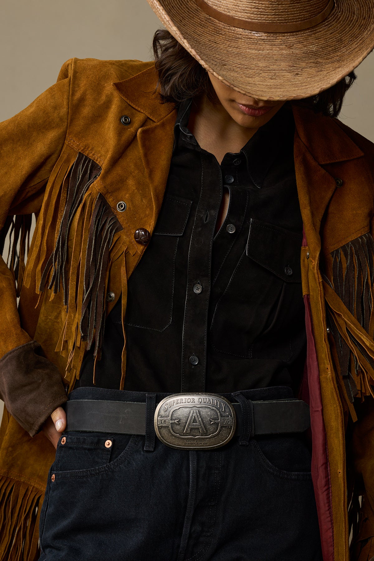 Black leather belt with silver pewter buckle worn with tan fringe jacket and cowboy hat
