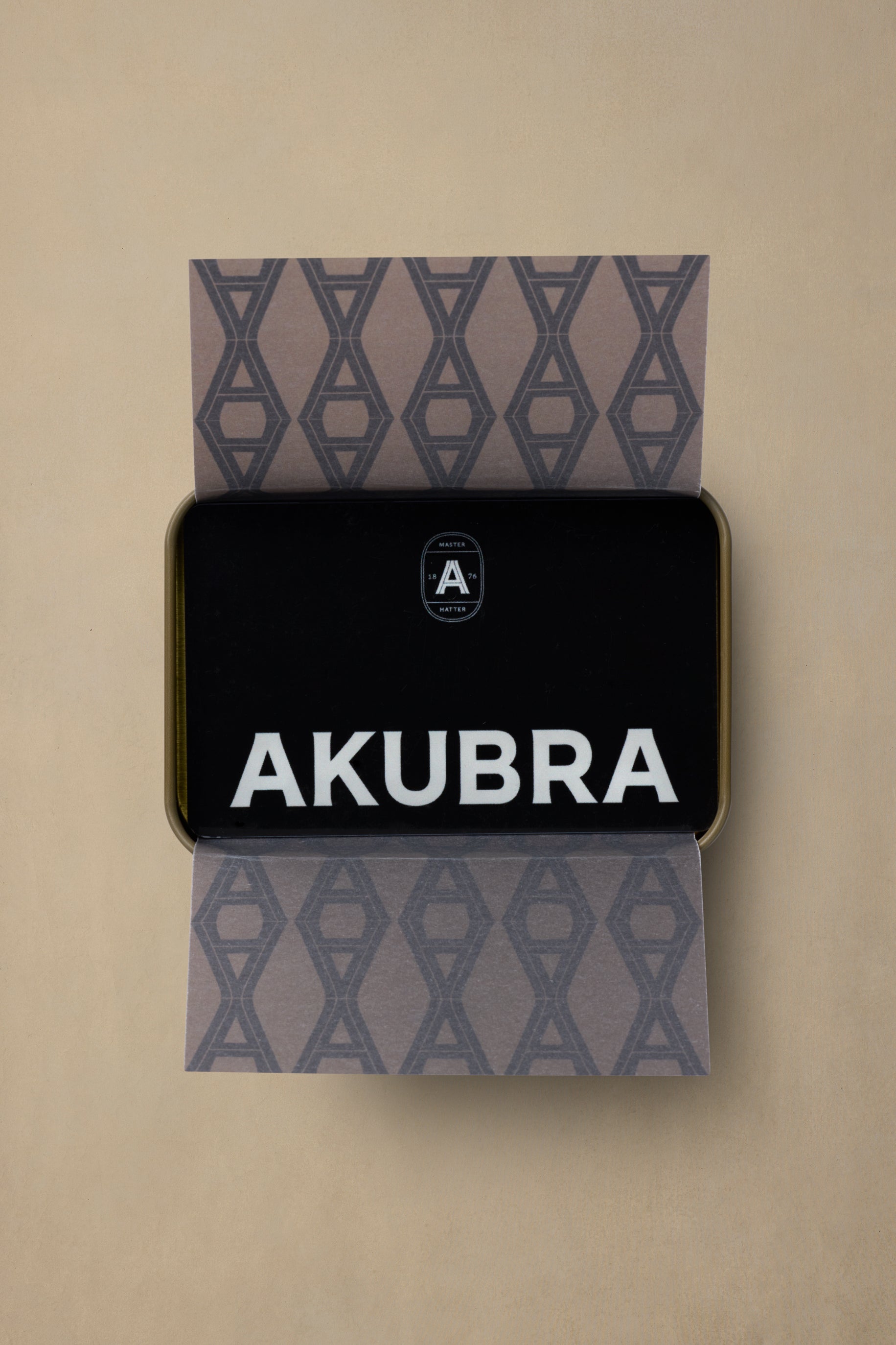 Akubra physical gift card in gold-trimmed black packaging with geometric patterned gray cardstock sleeve