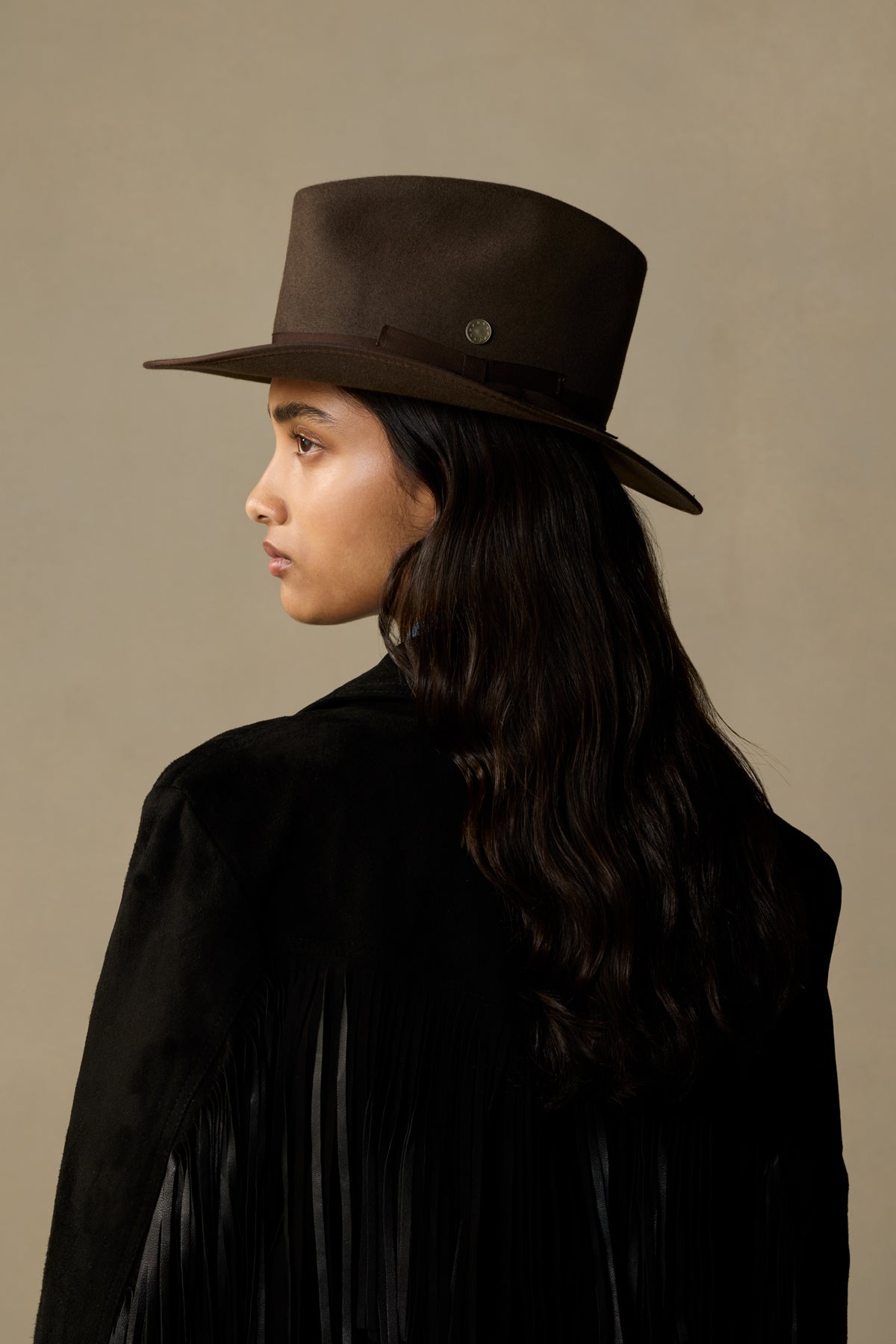 Mid brown rabbit fur felt hat with leather band, shown on model in profile view against neutral background