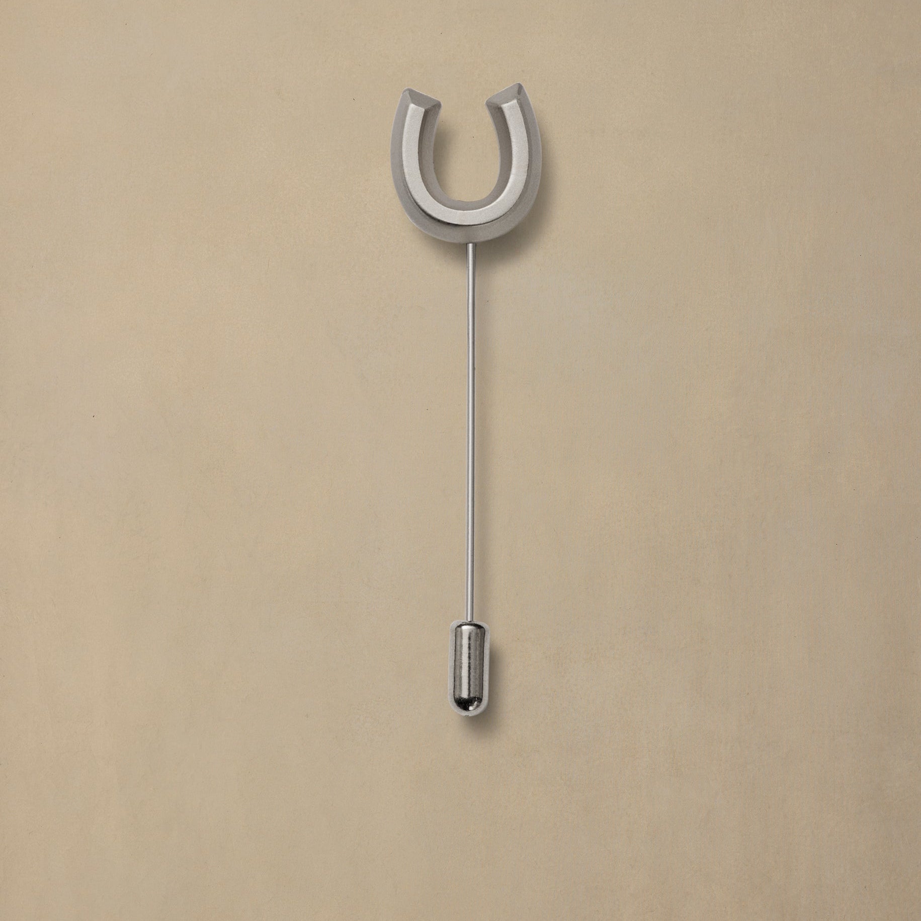Lucky Pewter horseshoe pin with long stem on neutral background