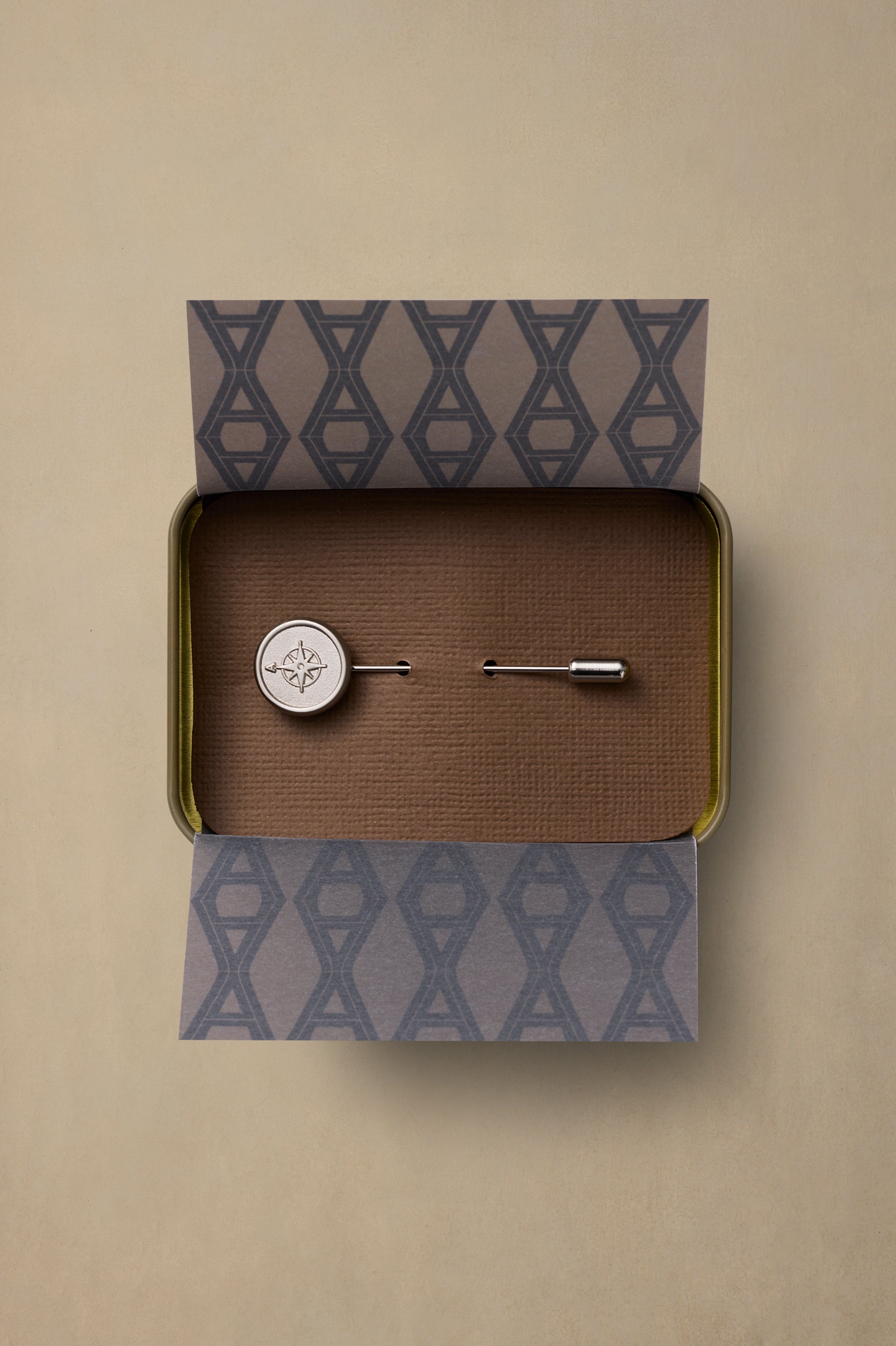 True North pewter compass pin with silver finish in branded gift box with geometric pattern