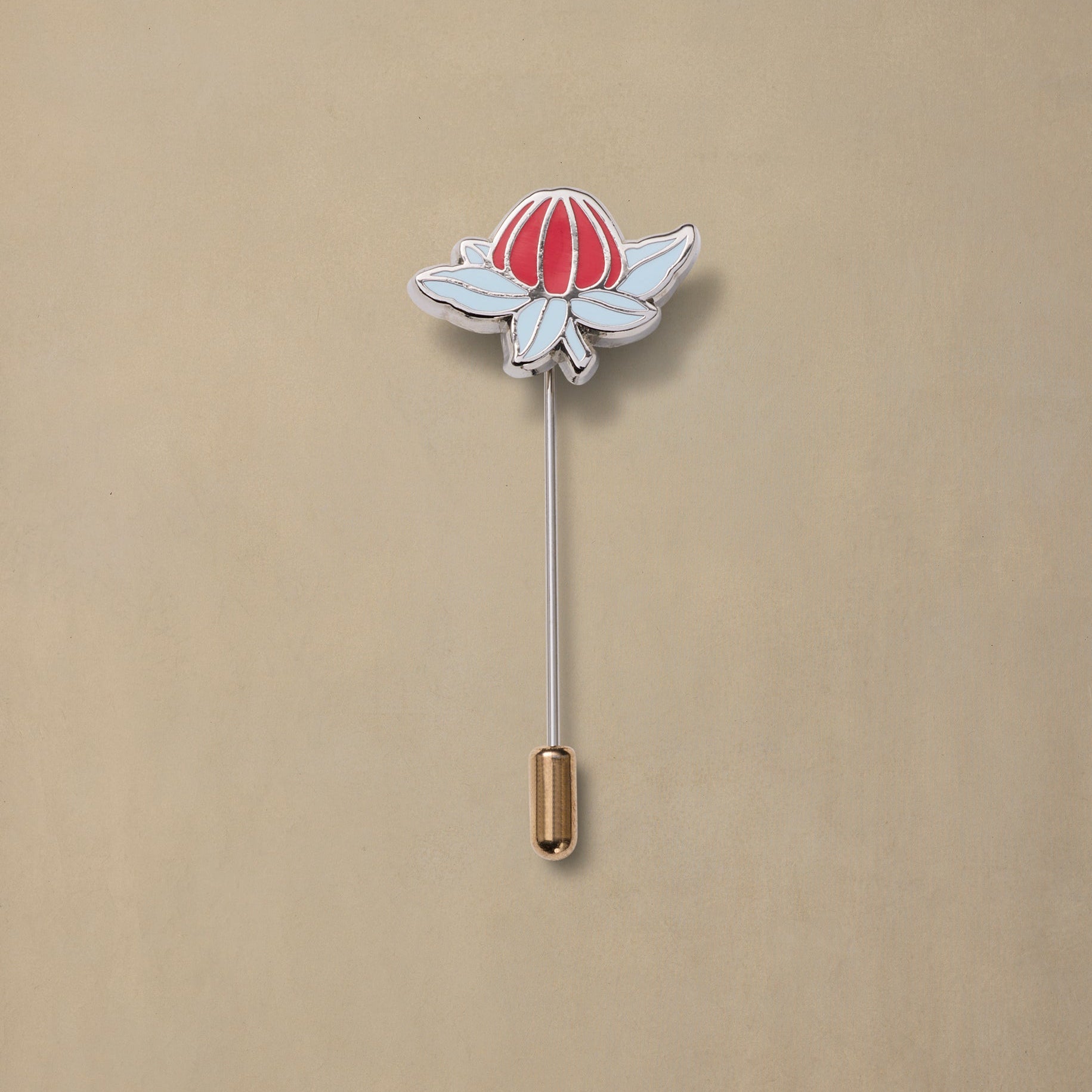 Waratah flower enamel pin with red petals and white base, silver metal stem, wooden backing on beige background