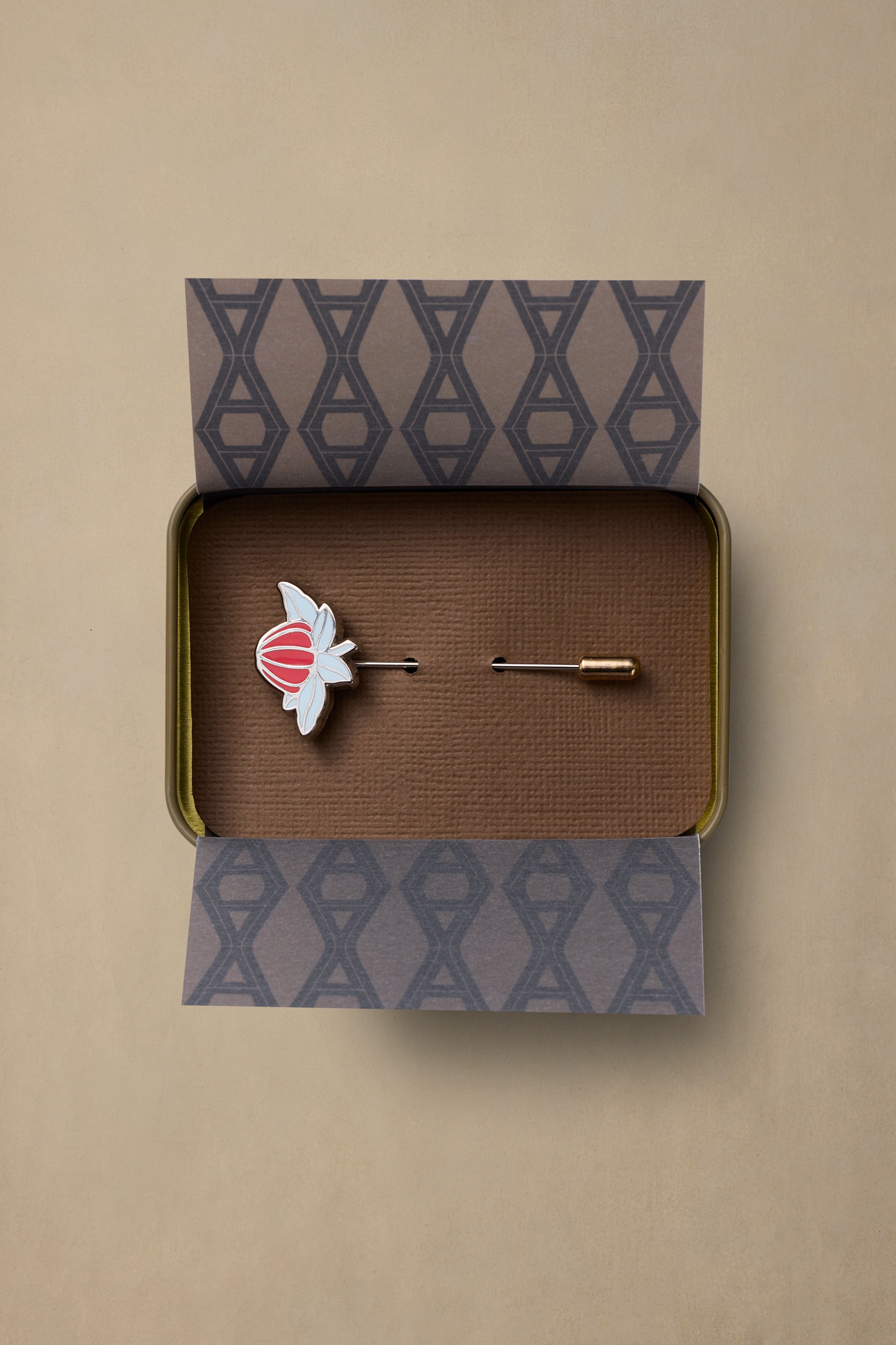 NSW State enamel pin with red and white flower design in branded gift box with patterned tissue paper