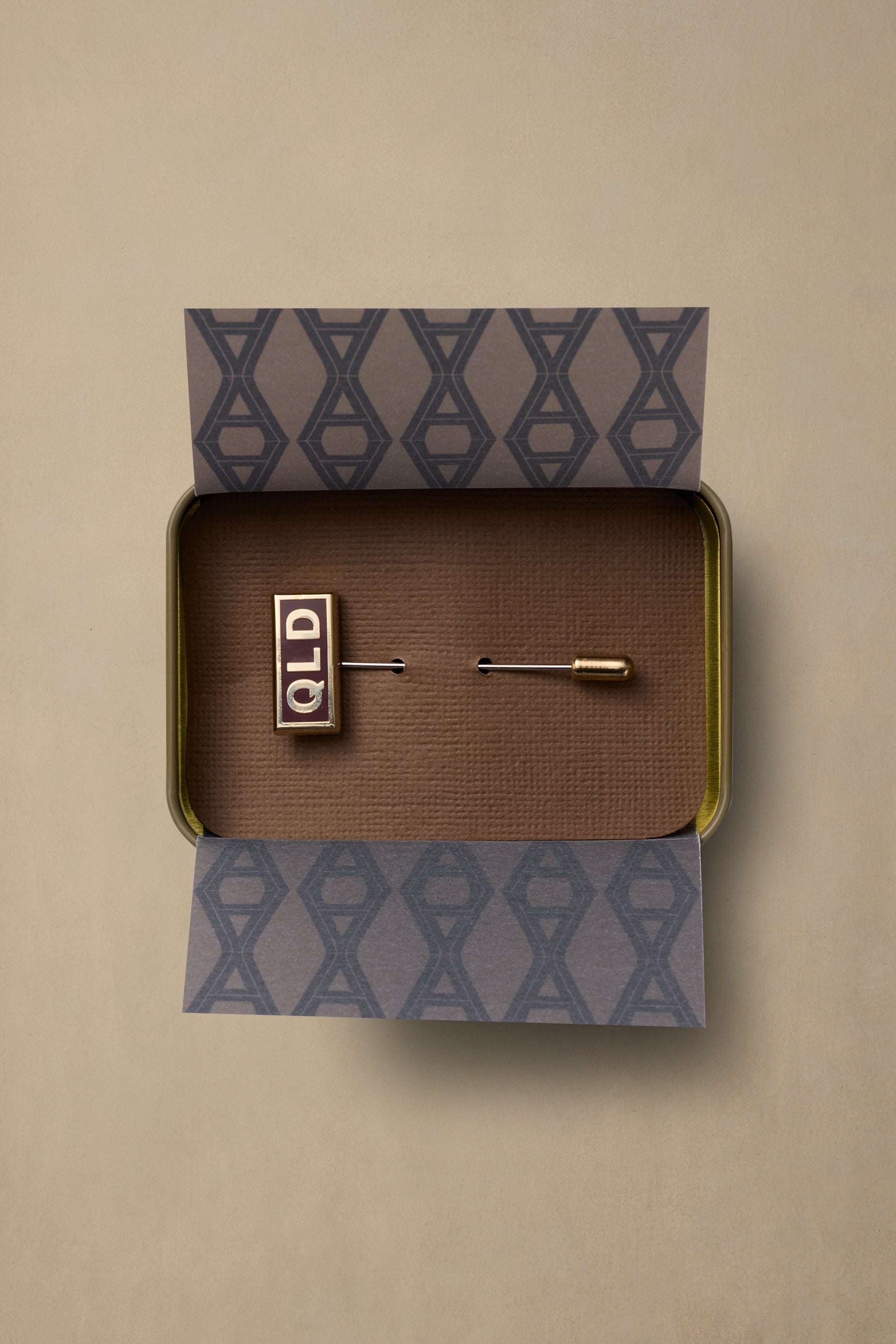 QLD State pin with gold finish in branded gift box with patterned tissue paper