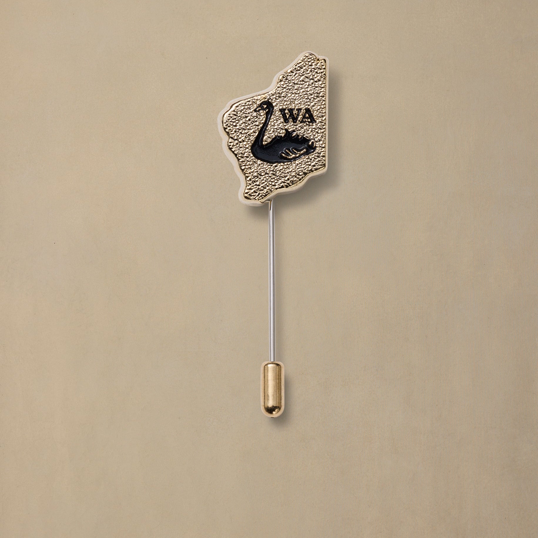 Gold textured Washington state pin with black swan emblem and silver stick post on cream background