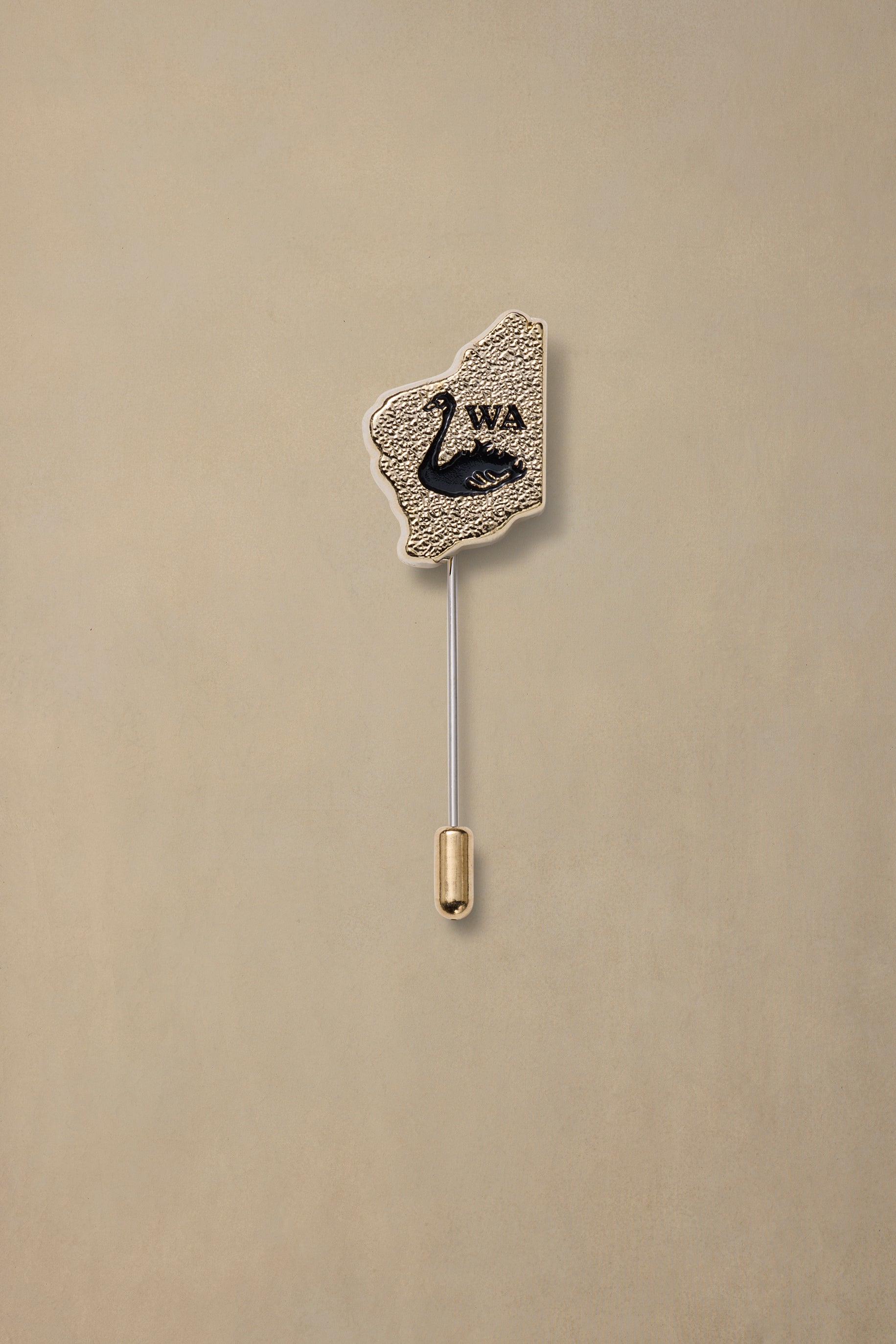 Gold textured WA state pin with black swan design and metal backing on cream background