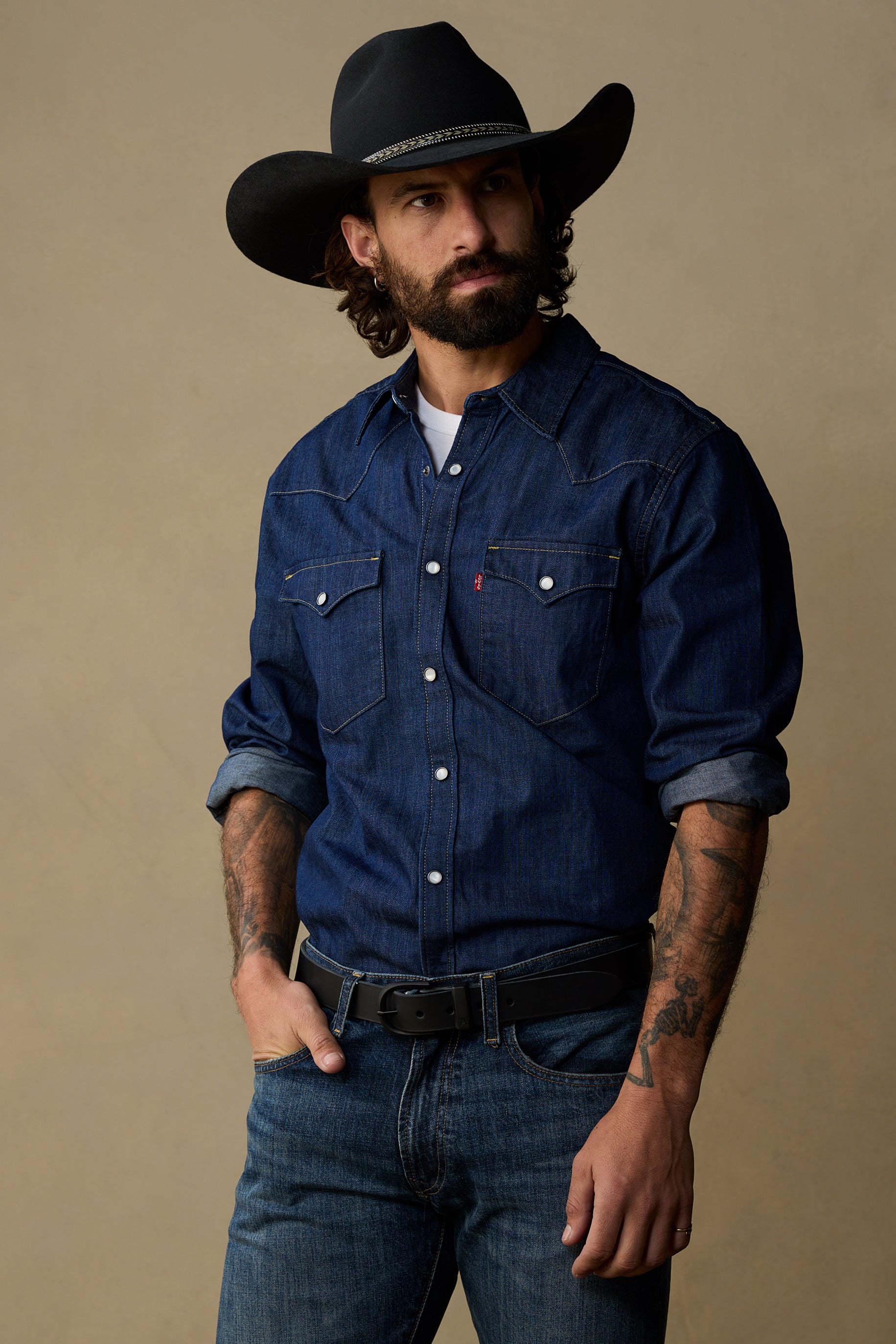 Black leather belt worn with denim shirt and cowboy hat, showcasing 30mm width and classic western style