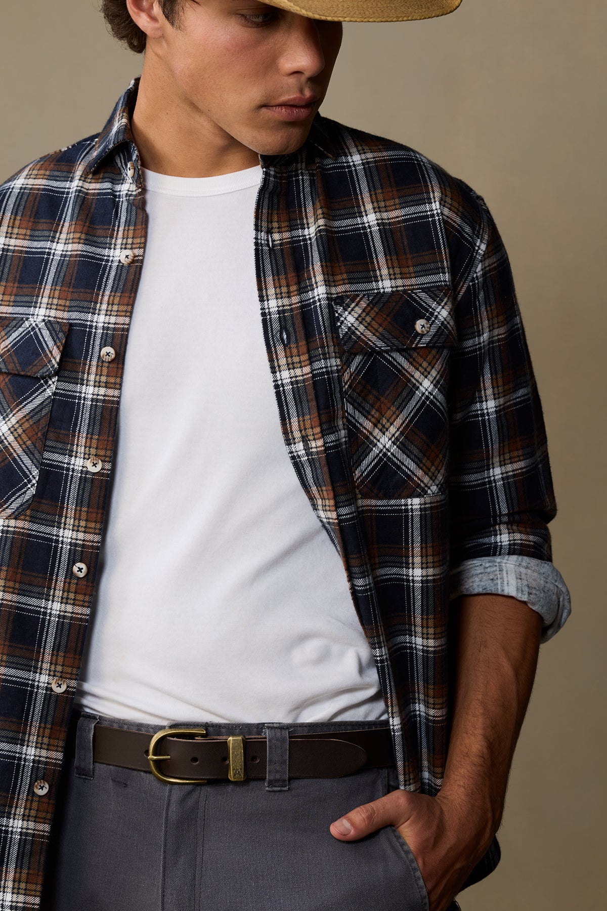 Chocolate brown leather belt with brass buckle worn with plaid shirt and white tee