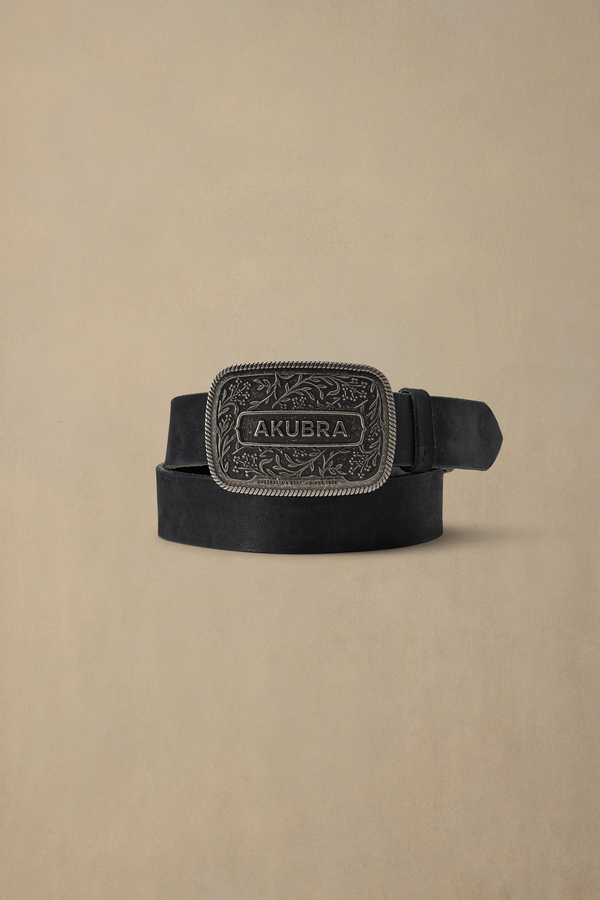 Black leather belt with ornate pewter buckle featuring floral engraving and Akubra branding, displayed flat on neutral background