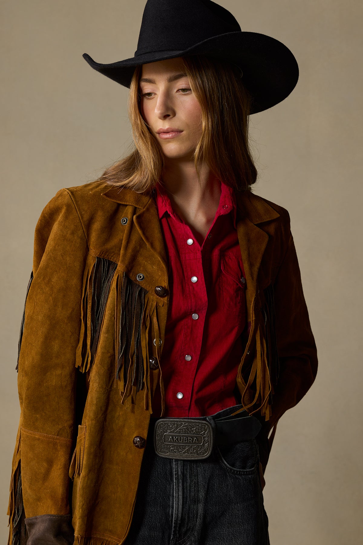 Black pewter leather belt with ornate buckle worn with brown fringe jacket and red shirt